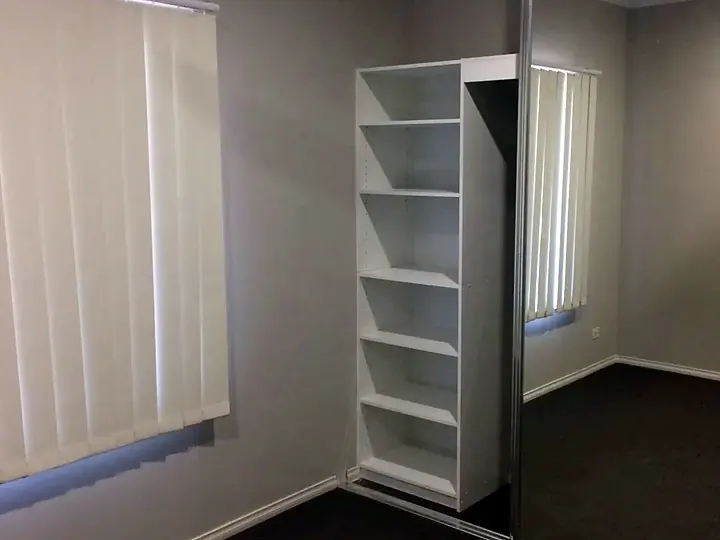 Mirrored sliding wardrobe doors in an empty bedroom